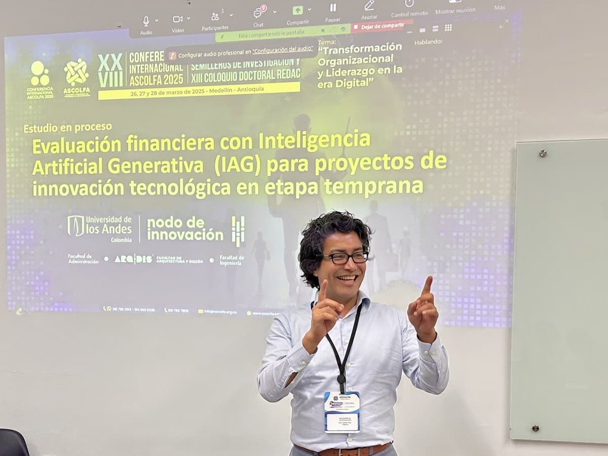Augusto Ruiz presenta, con los dedos en alto y sonriendo, frente a una pantalla sobre evaluación financiera con inteligencia artificial generativa para proyectos de innovación tecnológica, en un evento académico de la Universidad de los Andes.